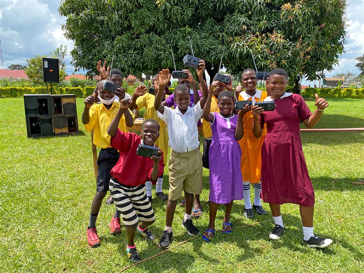 Elever fra Uganda viser frem solcellelampene de har fått
